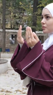 Dışarıdaki Müslüman duası, cami avlusunda ellerini kaldırarak dua eden beyaz bir kızın görüntüsü, İslami ibadet ve turistik mekan.