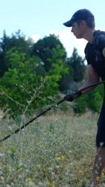 Genç çiftçi koleksiyon damlaları, bahçede çalışan adam, damlama sulama sistemi toplayan adam.