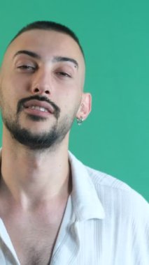 Disregardful facial expression, facial gestures of male model rudely chewing gum, facial expressions image taken portrait in front of green screen