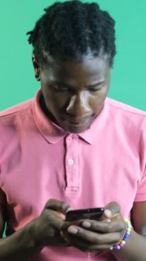 Telefondaki kötü haberlere bakan, telefona bakarken kötü bir şeyle karşılaşan, yeşil ekranın önünde vücut dilini ve yüz ifadelerini gösteren bir adam.