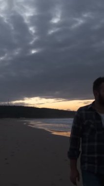Kıyı manzarasının ve bulutların ardında gezinen kişinin yüz profilinden bir video.
