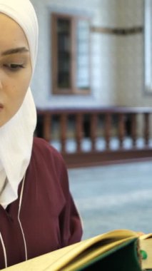 Müslüman Kız Kuran okuyor, Asyalı tesettürcü kız caminin içinde Kuran okuyor, Kuran okuyor, İslam 'a tapıyor.