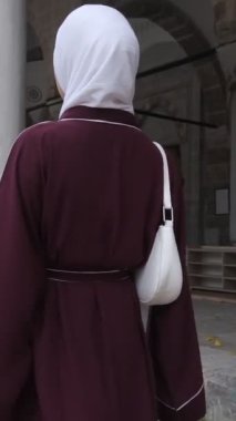 Hijabi Kız Tarihi Kesme Bahçesinde, ünlü Osmanlı camileri gezisi teması, avluda yürüyen Müslüman turist, kültürel ve dini geziler