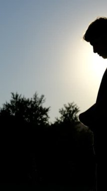 Siluet genç adam namazı, Siluet Müslüman dua videoları, inanç dolu bir hayat, bir müslüman olarak yaşamak, dua eden genç bir adamın görüntüsü.