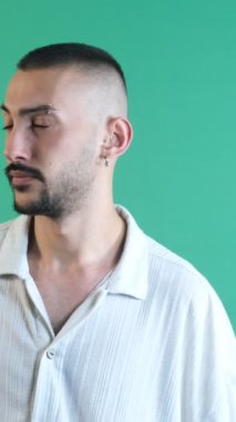 Thoughtful facial expression, Image of young male thoughtfully putting his hand to his head, image of emotions and facial expressions taken in front of the green curtain