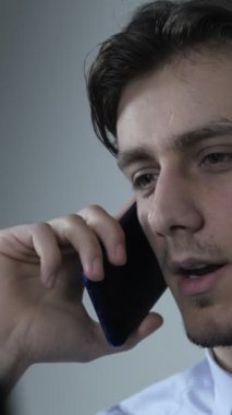 Genç işadamının telefonu, ekranın önünde oturan gömlekli adamın görüntüsü telefonda iş görüşmesi kavramı.