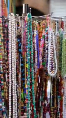 Hediyelik eşya dükkanında kullanılan ardışık boncuklarla oluşturulan tespihlerin resmi, turist temalı el yapımı hediyelik eşyalar. Ziyaret ettikleri ülkeden hediyeler.