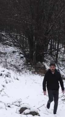 Kış aylarını ve soğuğu donmuş çalılıklarda yürüyerek geçirmek isteyen adamın görüntüsü.