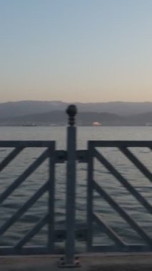 Sahilde deniz kenarında yürüyen genç bir kadının görüntüsü, işten sonra hareketli yürüyüş yapan şapkalı bir kadın.