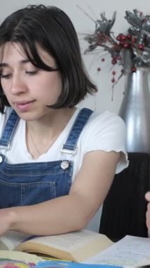 İki genç kadının kapalı alanda birlikte okuduğu, ev ödevlerini hazırlayan bilgisayar ve kitapları kullanan, edebiyat araştırması yapan iki kızın görüntüleri.