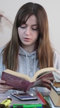 Çalışırken müzik dinleyerek mola veren genç bir kız, ev ödevine ara veriyor, kulaklıkla müzik dinleyerek derslerine ara veriyor.