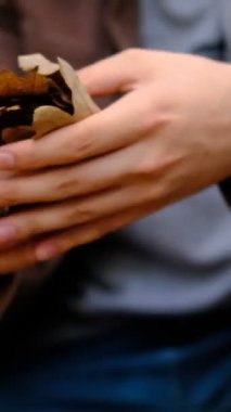 Kahverengi yaprakları yere atan adam sonbaharda ağaçların yeşil yaprakları kurur ve yere düşer.