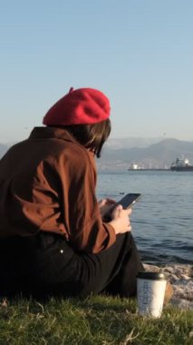 İşten sonra akıllı telefonu ve kahve fincanıyla oynarken palmiye ağaçlarının altındaki bir parkta dinlenme fikri çok hoş.