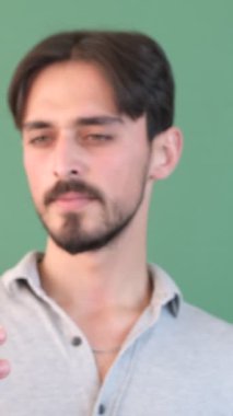 Akıllı telefon yeşil ekran adamı, telefonu kroma anahtarının önünde elinde tutuyor, telefonu tutan adam yeşil arka planı izole ediyor.