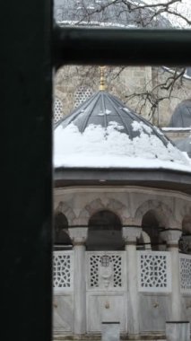 Kapıdan girerek camiyi ziyaret eden genç bir kadın, camileri ibadet yeri olarak ziyaret ediyor.