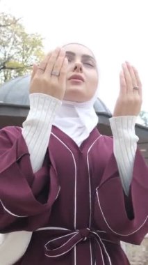 Müslüman Kız Namaz Kılavuzu, caminin avlusunda ellerini havaya kaldırarak dua eden bir kızın görüntüsü, İslami dua teması