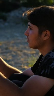 Genç adam dua ediyor, doğada ibadet ediyor, farklı inanç ve dinlere sahip, elleri açık ve Tanrı 'ya, inançlara ve inançlara dua ediyor.