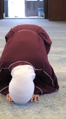 Asyalı Kız secde ediyor, Müslüman kız secde ediyor, İslam 'da namaz kılıyor, camide dua ediyor, secde ediyor.