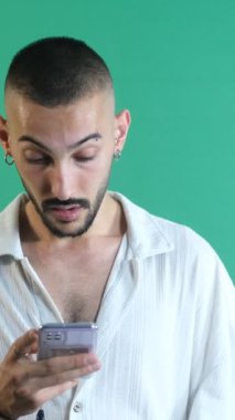 Telefondan, duygulardan ve yeşil ekranın önündeki modelin yüz ifadelerinden aldığı haberle çok şaşıran adam.