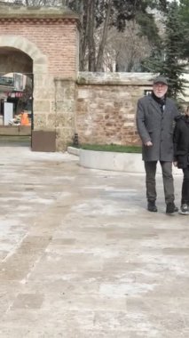 Büyükbaba ve torun cami bahçesinde vakit geçiriyorlar, mermerden yapılmış minder camisinin avlusunda vakit geçiriyorlar.