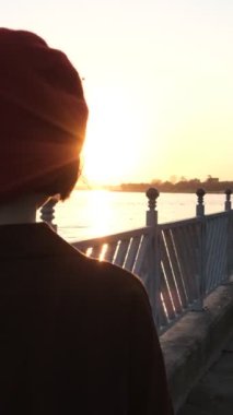 Gün batımına doğru yürüyen güzel bir kadın resmi, deniz ve gökyüzünün mavi manzarası, iş, Palm Park 'ta gün batımı.