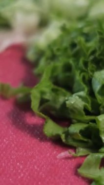 Yeşil marullu salata yapmak için doğrama ve akşam yemeği için salata hazırlama konsepti.