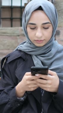 Sohbet için akıllı telefon kullanan tesettürcü kız, Müslüman kadın telefon yeşil ekran, teknoloji uygulaması kullanan yeşil ekran islamik uygulamalar