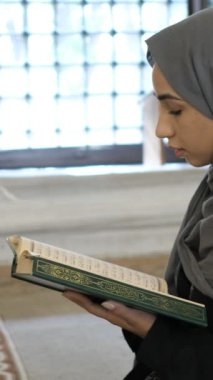 İslami kutsal kitabı okuyan genç Müslüman, camide Kur 'an okuyan, Kuran okuyan, Mescid' de dua eden hijabi kızı.