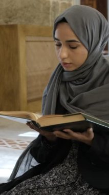 Genç Müslüman, Müslüman bir kadın camide kutsal Kuran okuyor, Kuran 'dan dua eden bir kız, İslam kuralları.