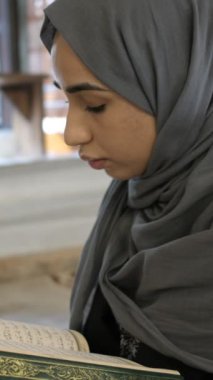 Hijab 'lı genç kadın Kuran okuyor. Tarihi Osmanlı Camii' nde barışçıl Müslüman kız. 