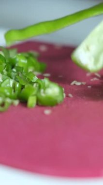 Pembe doğrama tahtasında yeşil biber kesme, yeşil biberleri bıçakla ince ince kesme, mutfakta yemek hazırlama görüntüsü