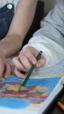 Haritadan ev ödevi yapan kızlar, masanın üstünde kitaplar, birlikte okuyan öğrencilerin yakın plan resimleri, kitapları tarayan araştırmacılar.
