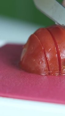 Domatesleri pembe doğrama tahtasıyla kesme, sebzeleri bıçakla kesme, mutfakta yemek hazırlama manzarası