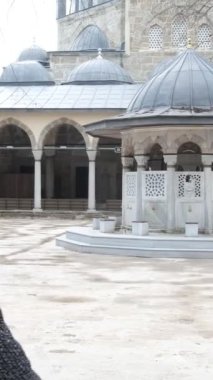 Büyükbaba ve torun caminin avlusuna kraliyet kapısından giriyor, aile tarihi camiyi ziyaret ediyor.