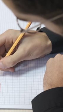 Öğrenci Geometri Masası, not defterine renkli kalemlerle notlar alan, tükenmez kalemle deftere şekiller çizen adam.