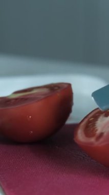 Domatesleri pembe doğrama tahtasıyla kesme, sebzeleri bıçakla kesme, mutfakta yemek hazırlama manzarası
