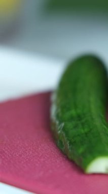 Salatalık doğrama manzarası, salatalık doğrama manzarası, pembe kesim tahtasındaki salatalık manzarası, sebze doğrama görüntüsü...