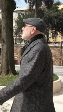 Mermerden yapılmış caminin manzarası, cami bahçesindeki şadirvan manzarası, camiyi ziyaret eden Müslüman adam.