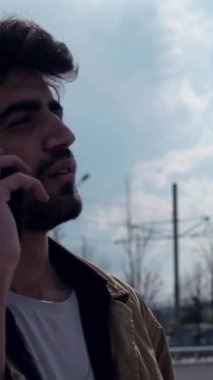 Köprüde dikilen genç erkek telefonu kaldırır ve ciddi bir gencin telefonda konuştuğu yakın plan bir konuşmaya başlar.