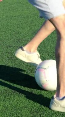Erkek ayaklarının halıda futbol topuyla oynaması, maçtan önce top sürerek genç erkek antrenmanı.