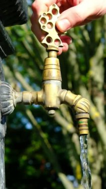 Açık havuzu açan ve ellerini yıkayan insanların yakın plan görüntüsü, insanlar parktaki fıskiyeden yararlanıyorlar.