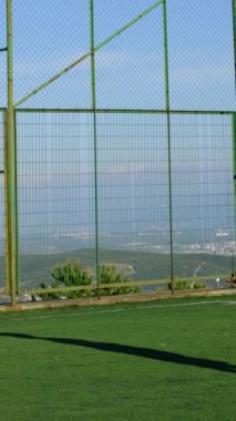 Halıda futbol oynayan iki genç adamın bakış açısı farklı. Maçtan önce iki arkadaş antrenman yapıyor.