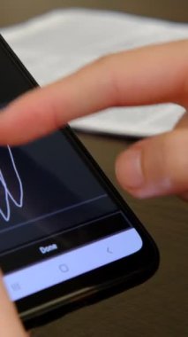 Ekrandaki çevrimiçi anlaşmayı okumak ve kabul etmek, dijital imzanızı atmak, telefondaki yazılı belgeyi incelemek, akıllı telefon üzerinde çalışmak