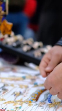 Genç turist sokakta durup hediyelik bilezik ve boncukları seyrediyor. Turist temalı bir imaj çiziyor, hediyelik eşya alıyor ve ülkeden hediyeler alıyor.