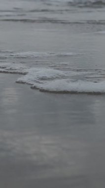 Sahildeki köpüklü dalgaların çarpışması, kıyı boyunca dalgaların hareketi, deniz ve kumsalın kesiştiği nokta.