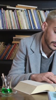 Genç bir adamın kütüphaneye arkası dönükken kitap okuması fikri, araştırmacının kitabını elinde tutması, gözleriyle okuduğu cümleler.