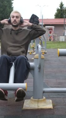 Mekik dinlerken, müzik dinlerken, spor yaparken, spor yaparken, gençlerin şehir parklarında sağlık faaliyetlerinde bulunurken, müzik dinlerken.