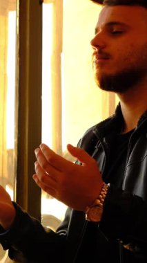 Camiinin içinde dua eden genç bir adam, İslami bir şekilde dua eden ve ibadet eden bir gencin görüntüsü.