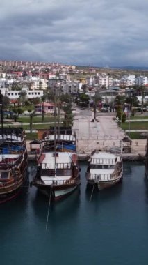 Deniz tarafından inşa edilmiş şehir manzarası ve arkasındaki dağlar parçalı bulutlu bir günde, deniz tarafından inşa edilmiş marinanın üst manzarası.