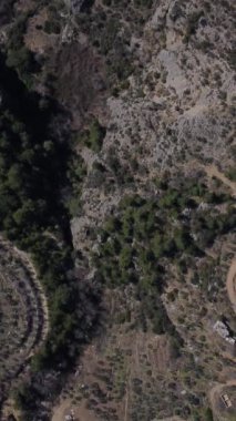 Toprak yolların hava manzarası vadideki ormandaki tarım arazilerine erişim sağlamak için açıldı, eğimli arazideki tarım faaliyetleri, eğimli orman yolu yamacı